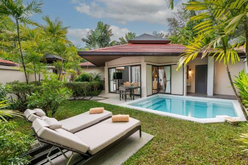 un patio trasero con piscina y una villa en Dewa Phuket Resort & Villas, en Nai Yang Beach