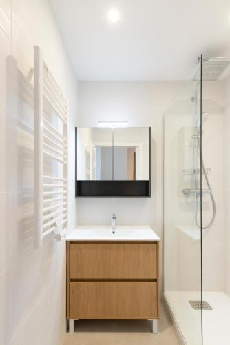 une salle de bain avec un lavabo et un miroir dans l'établissement Le Charmant de Catherine - Très bel appt à Nancy, à Nancy