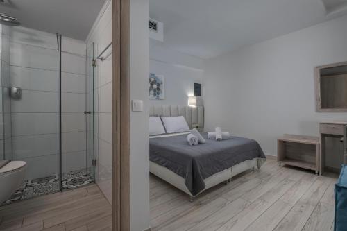 a bedroom with a bed and a bathroom with a shower at Adonis Luxury Village in Pefkohori