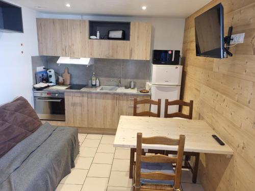 une cuisine avec une table et des chaises et une cuisine avec un évier dans l'établissement L'ourson, à Les Deux Alpes
