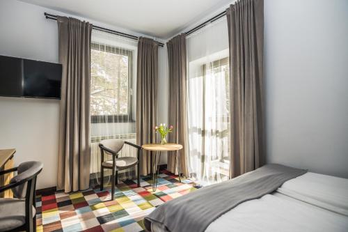 a hotel room with a bed and a table and chairs at OSW Pan Tadeusz in Krynica Zdrój