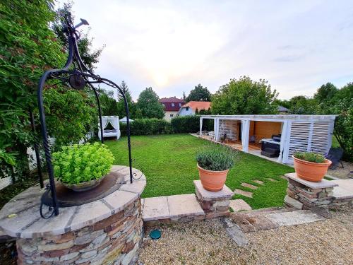 a garden with two potted plants in a yard at Vidéki Varázs Vendégház in Bogács