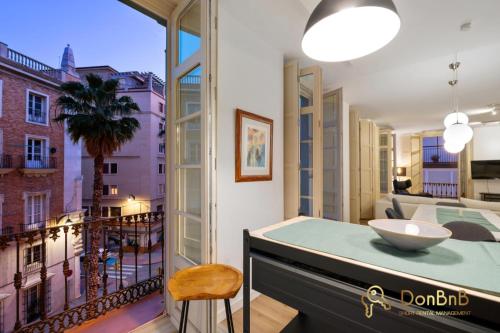 a room with a table and a balcony with a view at Exclusive Málaga Soho Apartment in Málaga