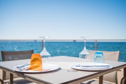 a table with two wine glasses on top of it at Tre Merli Beach Hotel in Trieste
