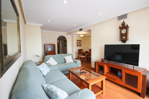 un salon avec un canapé bleu et une télévision dans l'établissement Expoholidays- Puerto Aguadulce 4ºG, à Aguadulce