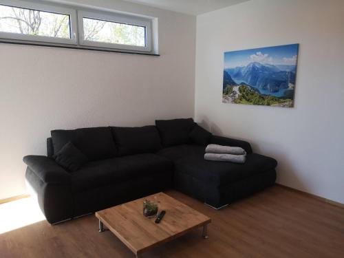 a living room with a black couch and a coffee table at Franzl Hof Zorell in Ravensburg