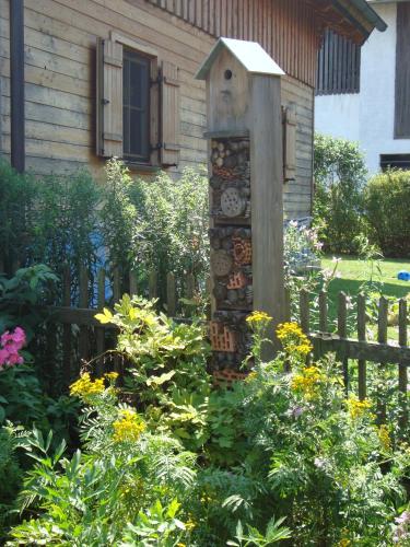 a garden with a wooden fence and a bird house at Ferienhaus Lenzenbauer in Salzburg