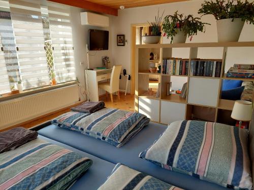 2 Betten in einem Zimmer mit einem Schreibtisch und einem Fenster in der Unterkunft Kakteengarten in Böchingen
