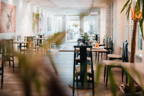 a restaurant with tables and chairs in a room at Tre Merli Beach Hotel in Trieste