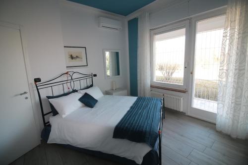 1 dormitorio con 1 cama y 2 ventanas en Villa Silvia Olivetti en Banchette