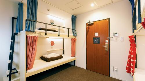een kamer met 2 stapelbedden en een deur bij WeBase Kyoto in Kyoto