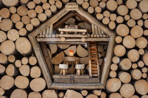 a small gingerbread man in a mirror in a pile of wood at DolomiApartments - Appartamento Orso Bruno in Predazzo