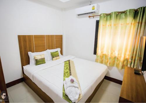 um quarto com uma cama com uma toalha em Staychill Resort em Uttaradit