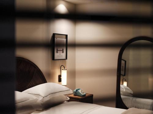 a bedroom with a mirror and a bed with white pillows at The Twentyone in Athens
