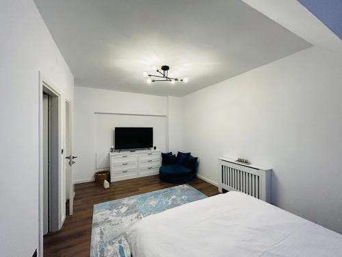 Un dormitorio con una cama y un televisor de pantalla plana. en Upon Boutique, en Sinaia