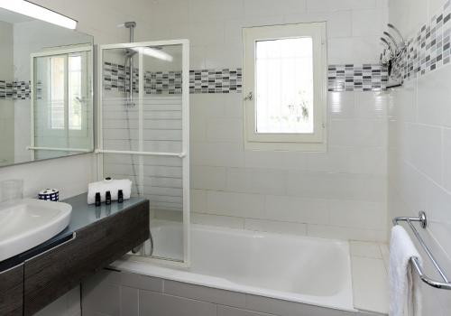 a white bathroom with a shower and a sink at SUQUETTE Charming provencal house in Antibes with nice terrace, garden and pool access in Antibes