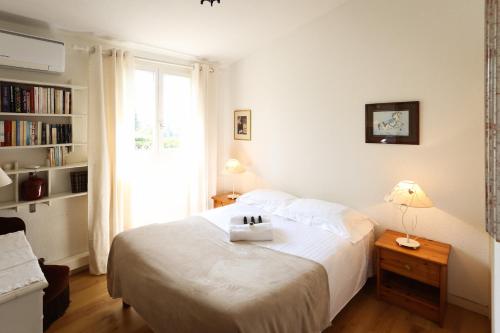 une chambre avec un lit blanc et une fenêtre dans l'établissement SUQUETTE Charming provencal house in Antibes with nice terrace, garden and pool access, à Antibes