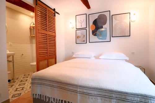 une chambre avec un grand lit blanc avec deux oreillers dans l'établissement AUBERNON Luxurious, Newly Renovated flat in heart of Old Antibes, à Antibes