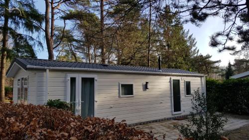 a small white shed with a black roof at Vakantiehuis Diever in Diever