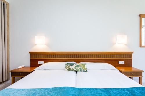 a bed with two lamps on top of it at Gara Suites Golf & Spa in Playa de las Americas
