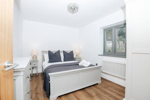a white bedroom with a bed and a window at The Oak - Brand new countryside 2 bedroom annex in Harpsden