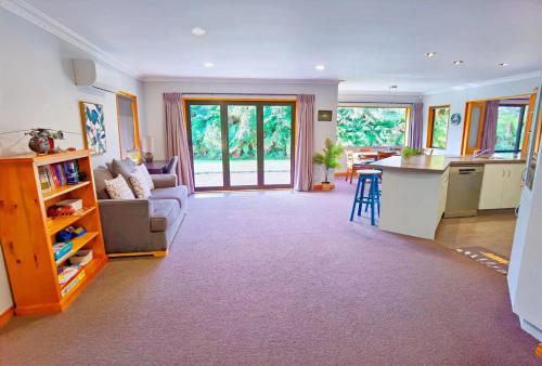 cocina y sala de estar con sofá y mesa en Tranquil Stream Villa en Rotorua