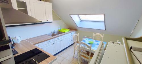 eine kleine Küche mit einem Tisch und einem Fenster in der Unterkunft Grand et bel appartement 77m2 avec jardin, à proximité immédiate des plages 1,8km in Berck-sur-Mer
