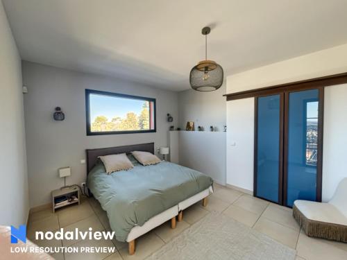 une chambre avec un lit et une fenêtre dans l'établissement Grande villa, magnifique vue & piscine, à Saint-Gély-du-Fesc