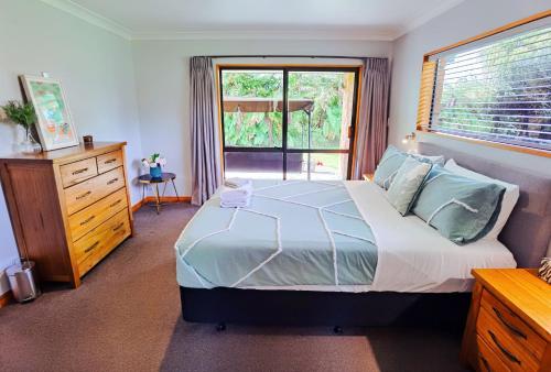 a bedroom with a large bed and a window at Tranquil Stream Villa in Rotorua