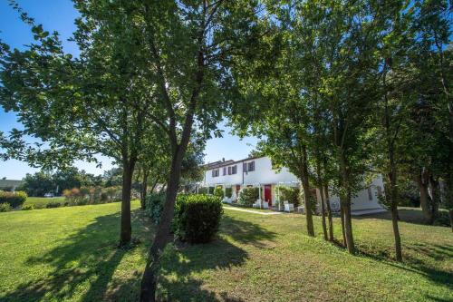 a white house with trees in the foreground at Agromarino in Sirolo
