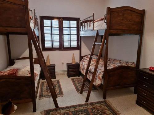 a bedroom with two bunk beds and a window at Dar Monia Aïn-Draham in Jendouba