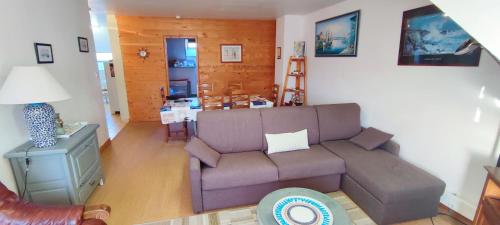 ein Wohnzimmer mit einem Sofa und einem Tisch in der Unterkunft Grand et bel appartement 77m2 avec jardin, à proximité immédiate des plages 1,8km in Berck-sur-Mer