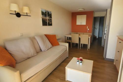 un salon avec un canapé et une table dans l'établissement Comfortable nest with pool and sea view, à Saint-Raphaël