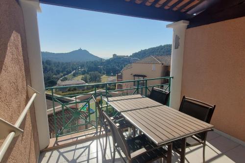 d'un balcon avec une table et une vue sur les montagnes. dans l'établissement Comfortable nest with pool and sea view, à Saint-Raphaël
