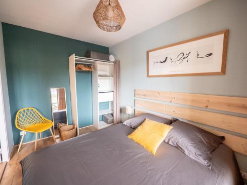 een slaapkamer met een bed en een geel kussen bij Apt 2/4 pers. Arcachon + Parking / Le Perchoir in Arcachon