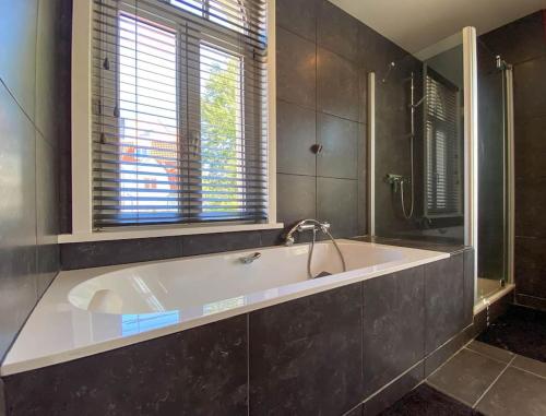 eine große Badewanne im Bad mit Fenster in der Unterkunft Villa Trianon -Summer beachhouse in De Panne