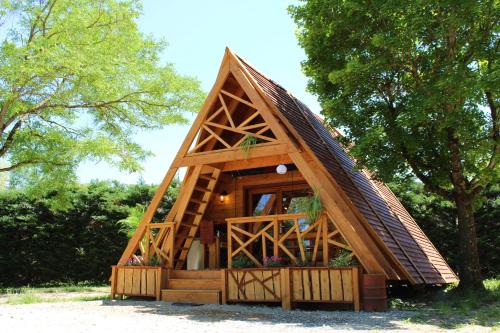 uma pequena casa na árvore com telhado de palha em Habitat Créateur - Hébergements insolites au camping municipal "Les Ecureuils" em Recoubeau