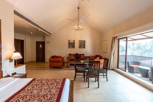 a bedroom with a bed and a dining room at Neelam's The Grand Hotel Goa in Calangute