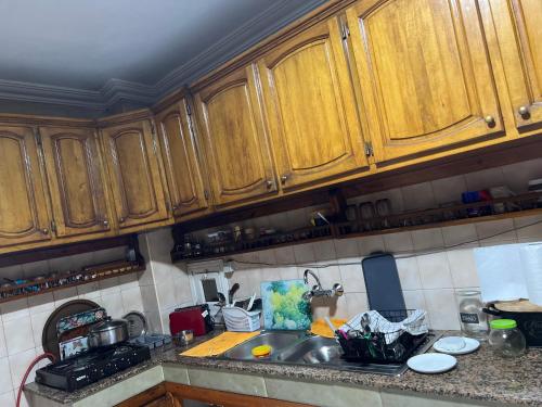 a kitchen with wooden cabinets and a sink at اقامة ربيعة in Casablanca