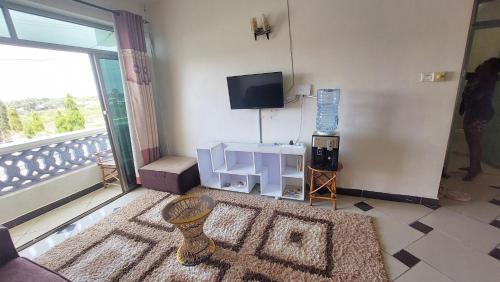 a living room with a flat screen tv and a room with a rug at Shanzu Mombasa One Bedroom & Swimming Pool in Shanzu