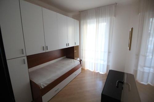 um pequeno quarto com uma cama e uma janela em Miramare em Arma di Taggia