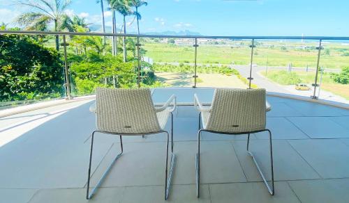 two chairs on a balcony with a view of the ocean at Holiday Inn Mauritius Mon Trésor by IHG in Blue Bay