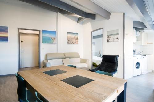 サン・マルタン・ド・レにあるAppartement Ombrineのテーブルと椅子、キッチンが備わる客室です。