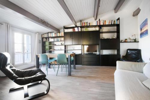 un salon avec une table, des chaises et un canapé dans l'établissement Appartement Ombrine, à Saint-Martin-de-Ré
