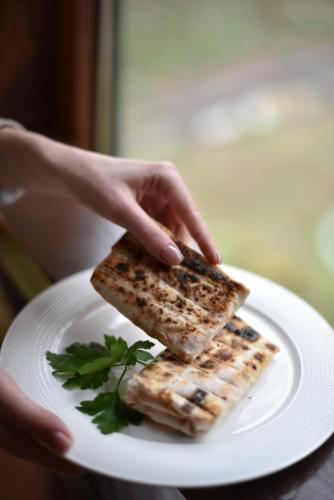 a person holding two pieces of toast on a plate at База відпочинку ШИПОВЕЦЬ in Poroškov