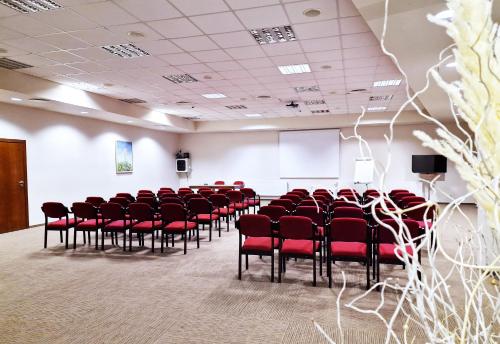 a conference room with red chairs and a white wall at Hotel Prezydencki 4-star in Rzeszów
