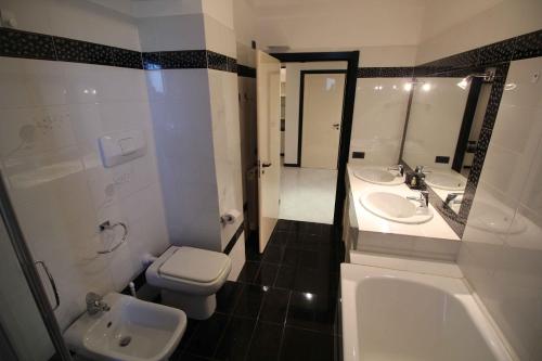 a bathroom with two sinks and a toilet and a tub at Miramare in Arma di Taggia