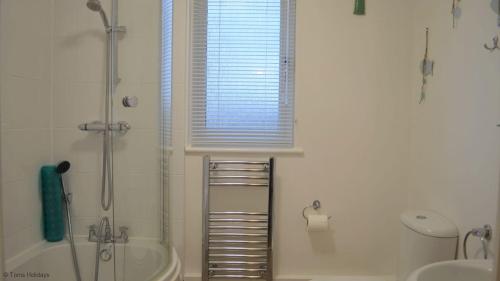 a bathroom with a shower and a tub and a toilet at 82 Strawberry Hill, Tolroy Manor in Hayle