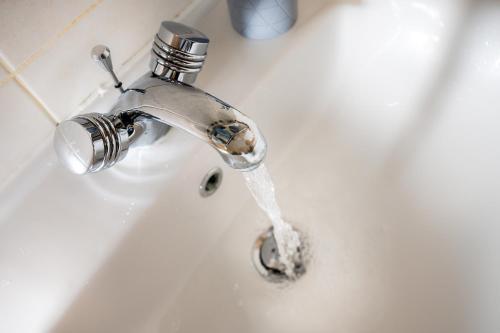 a bathroom sink with water running from a faucet at Scarlet Oaks, easy walk from Hospital in Frimley