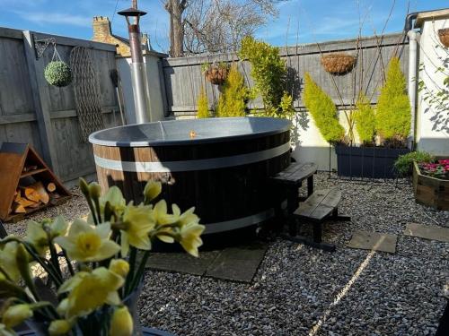 un pequeño patio trasero con bañera de hidromasaje en un jardín en Pear Tree Cottage en Bishop Auckland